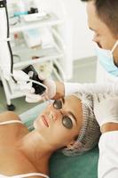 Doctor dermatologist and woman client during laser skin resurfacing treatment photo