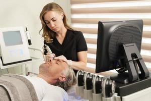 Middle aged man during deep facial cleansing in a cosmetology clinic photo