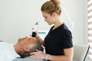 Middle aged man during carbon dioxide laser resurfacing in a cosmetology clinic photo