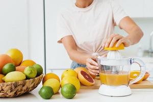 Female hands and citrus juicer during fresh orange juice preparation photo