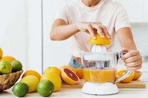 Female hands and citrus juicer during fresh orange juice preparation photo