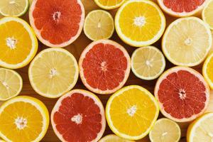 Different sliced citrus fruits such as grapefruit, orange, lemon and lime photo