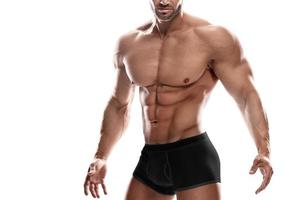 Muscular man wearing black underwear posing against white background photo