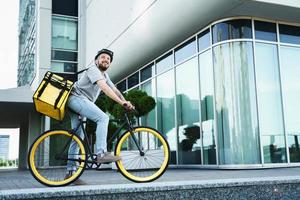 Express delivery courier standing on bicycle with insulated bag. photo