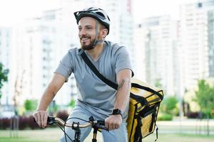 Express delivery courier riding bicycle with insulated bag. photo