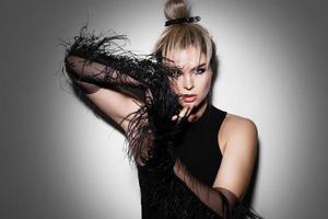 Fashion portrait of stunning woman wearing long tulle gloves with feather trims photo