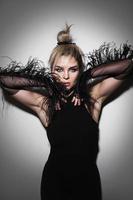 Fashion portrait of stunning woman wearing long tulle gloves with feather trims photo