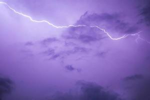 Lightning stroke in purple night sky photo