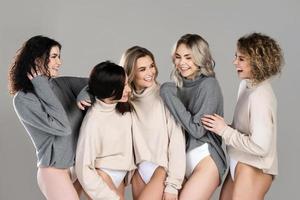 grupo de diferentes mujeres que usan puentes de cuello alto sobre fondo gris foto