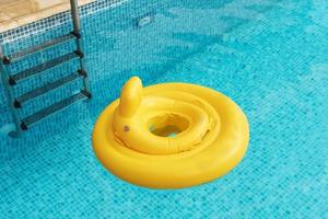 Inflatable baby float ring in open-air swimming pool photo