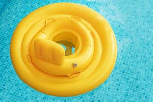 Inflatable baby float ring in open-air swimming pool photo