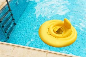 Inflatable baby float ring in open-air swimming pool photo