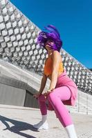 Carefree active woman dancer wearing colorful sportswear having fun on the street photo