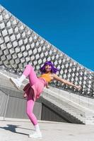 Carefree active woman dancer wearing colorful sportswear having fun on the street photo