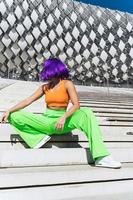 Active woman wearing colorful sportswear performing on the street during summer day photo