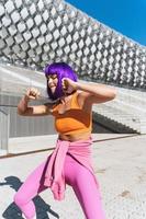 Carefree active woman dancer wearing colorful sportswear having fun on the street photo