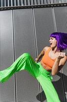 Carefree woman dancer wearing colorful sportswear having fun on the street during summer sunny day photo