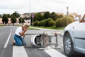 Horrified mother on the crosswalk after a car accident when a vehicle hits her baby pram. photo