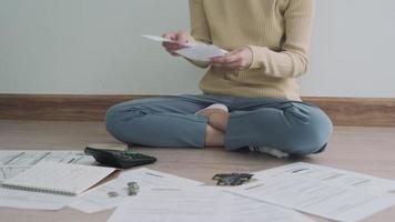Debt credit and financial problem concept. Asia woman is sitting and recheck on invoices and stress because not manage debt on month. woman covering face with hands and feel stressed.