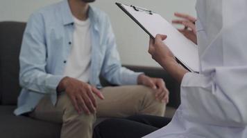 l'homme discute d'un problème de famille séparée avec un psychiatre. le psychiatre enregistre les détails et encourage à vivre. problèmes de santé mentale et dépression. video