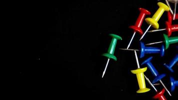 multicolored thumbtacks on a black background photo