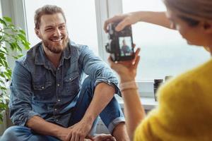 Woman photographer taking photos of her boyfriend at home