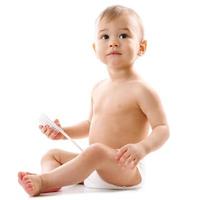 Little boy in diaper sitting and playing with brush. photo