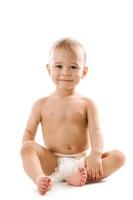 Curious healthy little boy in diaper sitting and smiling. photo