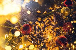 Bolas de decoración navideña con galletas y pasteles sobre fondo negro abstracto bokeh con espacio de copia y luces LED decorativas. feliz navidad y año nuevo. tarjeta de felicitación.