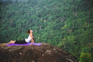 las mujeres asiáticas se relajan en las vacaciones. jugar si yoga. en el acantilado de roca de montaña. naturaleza de los bosques de montaña en Tailandia. mujer joven practicando yoga en la naturaleza felicidad femenina. ejercicio de yoga foto