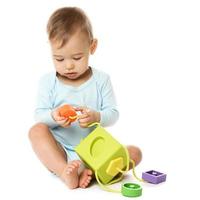 Little boy in romper sitting and playing with plastic toy. photo