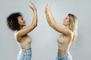 A high five between Caucasian and African American women. Concepts  interracial friendship or lesbian relationship. photo