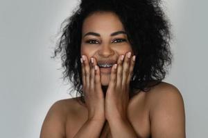 Smiling black woman with dental braces on her teeth photo