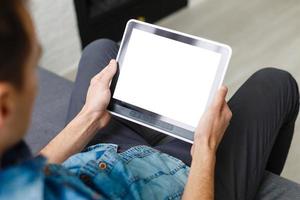 Man using tablet computer while sitting on a wooden floor. View from above. Clipping path included photo