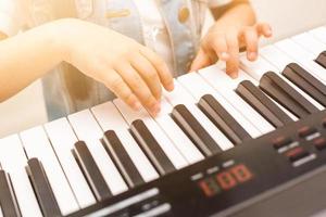 Hands of kid on piano keyboard photo