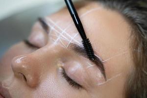 Woman during professional eyebrow mapping procedure photo