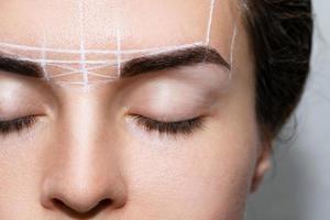 Woman during professional eyebrow mapping procedure photo