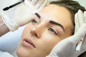 Woman during professional eyebrow mapping procedure photo