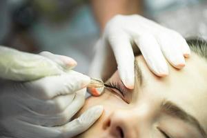 Young woman during professional permanent makeup treatment photo