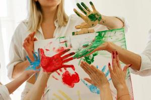 palmas femeninas en coloridos colores de pintura del arco iris que crean obras de arte modernas para apoyar a la comunidad lgbt foto