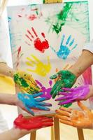 palmas femeninas en coloridos colores de pintura del arco iris que crean obras de arte modernas para apoyar a la comunidad lgbt foto