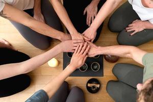 Women friends putting hands together during tea ceremony. photo