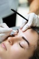 Woman during professional eyebrow mapping procedure photo