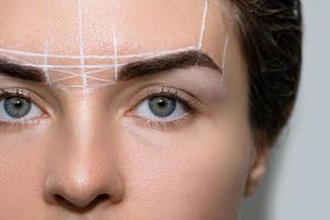 Woman during professional eyebrow mapping procedure photo