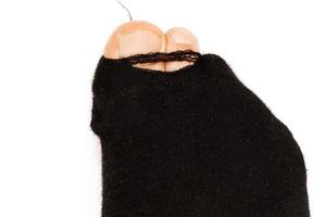 Closeup shot of black holey sock with sticking out toes. photo
