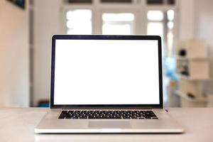 Close up Laptop Computer on Top of Office Table of a Businessman with Empty White Screen, Emphasizing Copy Space. photo