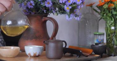 ceremonia del té chino. tetera de arcilla hecha a mano de estilo chino. camara lenta . ceremonia del té chino. tetera de arcilla hecha a mano de estilo chino. filmación en cámara lenta. flores silvestres de color lila. parte 8 video