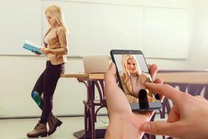 use mobile phone, blur image students and teachers are meeting as background. photo