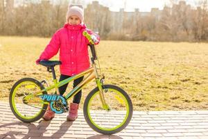 Smiling little girl on a bicycle photo