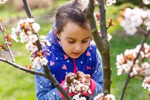 Cute spring fashion girl under blossom magnolia tree photo